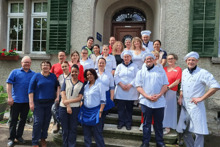 Gruppenfoto des Teams von Tertianum Grünegg auf der Treppe des Gebäudes
