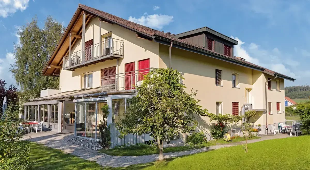 Aussenansicht des Hauses Tertianum Lindenegg mit Terrasse und Garten