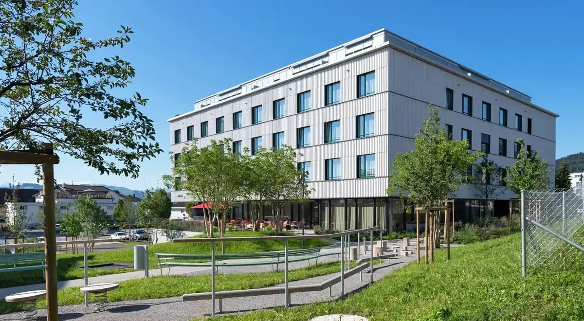 Das Gebäude des Tertianum Rosenau mit einem Sitzplatz im grünen Garten
