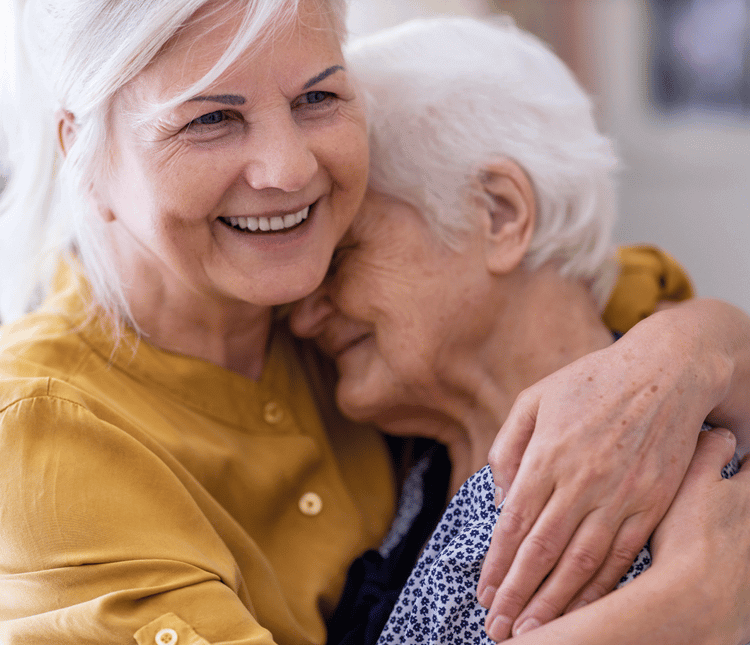 zwei alte Damen, die sich vor Freude umarmen